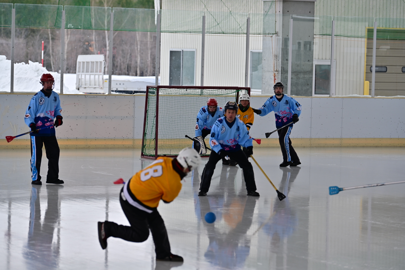 Goal-mouth action with a player shooting while defenders block